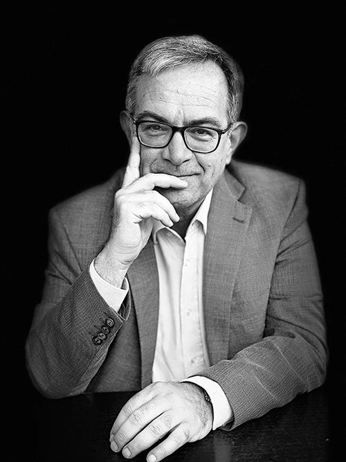 Luca Bianchini, musicologo e filologo, in una foto a mezzo busto in bianco e nero. Luca Bianchini, musicologo e filologo, in una foto a mezzo busto in bianco e nero. Lo sguardo sorridente è rivolto all'osservatore, la mano sollevata all'altezza della bocca, l'indice della mano detsra sulla giancia, il medio sulle labbra, quansi a interrgogarsi